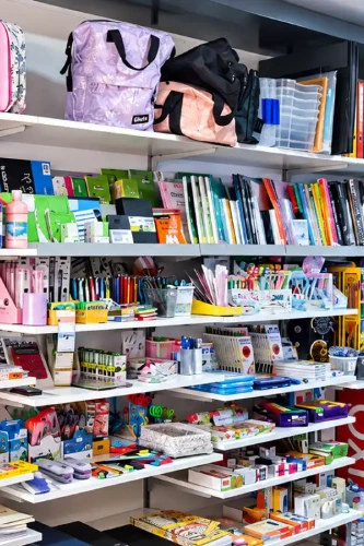 Prateleiras da Mundo de A a Z com artigos de papelaria, cadernos, canetas e acessórios escolares